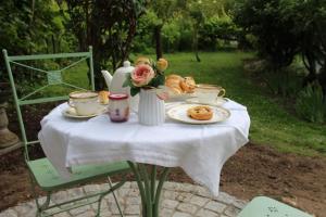 einen Tisch mit einem Teller Essen und Blumen darauf in der Unterkunft Belle Vue Terrasse in Giverny