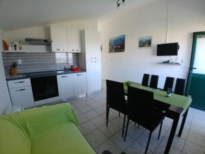 a kitchen with a couch and a table with chairs at Apartments Sali Village in Sali