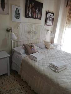 een slaapkamer met een wit bed en handdoeken bij Il centro di Napoli in Napels