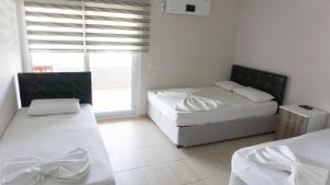 a bedroom with two beds and a window at Mer Apart Pansiyon in Avşa Adası