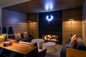 a living room with a fireplace and a table at Limelight Hotel Snowmass in Snowmass Village