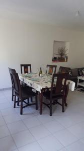 uma mesa de jantar com cadeiras e um piso branco em Gîte O'Cigales em Sablet