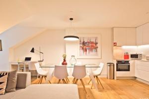 uma cozinha e sala de jantar com mesa e cadeiras em Penthouse with River View - Baixa Alfama em Lisboa