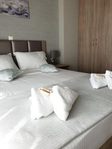 a bed with two pillows and two towels on it at Villas Mamas Beach in Agios Mamas