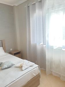 una camera con letto e finestra con tende di Villas Mamas Beach a Agios Mamas