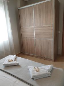 ein Schlafzimmer mit zwei Handtüchern auf einem Bett und einem Kleiderschrank in der Unterkunft Villas Mamas Beach in Agios Mamas