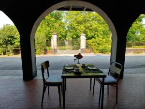 ein Tisch und Stühle in einem Raum mit offenem Fenster in der Unterkunft Corte Mantovanella in SantʼAntonio