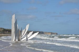 a sculpture on the beach next to the ocean at Villa kahlo Omaha Beach in Colleville-sur-Mer