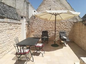 a table and chairs with an umbrella on a patio at Edoné in Locorotondo
