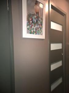 a bathroom door with a picture on the wall at Charmant F2 Paris Expo Versailles in Vanves