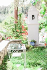 a table in the grass next to a bird house at Afroditi Pansion in Agios Nikitas