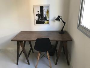 a wooden desk with a black lamp and a chair at Locking's Grajaú 7 in Belo Horizonte