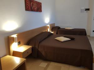 オストゥーニにあるGuest House B&B Pietra Biancaのベッド2台とテーブルが備わるホテルルームです。
