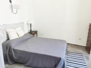 a bedroom with a bed with a gray blanket at Pinheiro de Monsaraz-Casas da Colmeia T2 in Reguengos de Monsaraz