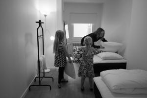 a man and two little girls in a bedroom at Jönköping Vandrarhem in Jönköping