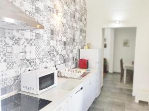 a kitchen with a white microwave on a counter at Pinheiro de Monsaraz-Casas da Colmeia T2 in Reguengos de Monsaraz +16 photos