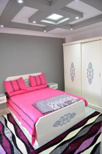 a bedroom with a pink bed in a room at City Square Bay View in Alexandria +39 photos