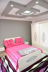 a bedroom with a pink bed with pink pillows at City Square Bay View in Alexandria