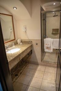 a bathroom with a sink and a shower at Hotel Ticuán in Tijuana