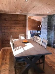 uma sala de jantar com uma mesa de madeira e cadeiras em Harpefossen Skisenter og Hyttegrend em Nordfjordeid