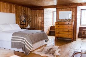 a bedroom with a bed and a dresser with a television at Le Vieux Presbytère in Saint-Vallier