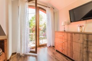 a bedroom with a dresser and a sliding glass door at Cavilla - Pokoje i Apartamenty in Sztutowo