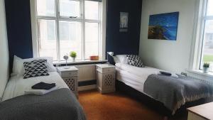 een slaapkamer met 2 bedden en een raam bij Refurinn Reykjavik Guesthouse in Reykjavík