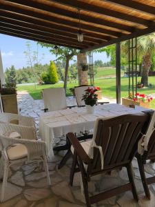 シビリにある3 Bedroom Villa in Elani Villas Chalkidikiの木製テーブルと椅子付きのパティオ