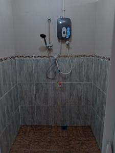 a shower with a shower head in a bathroom at Homestay pekan ranau in Ranau