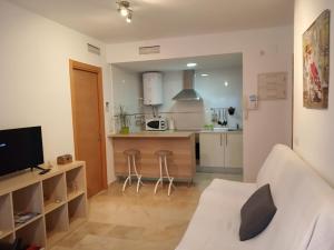 Il comprend un salon avec un canapé et une cuisine. dans l'établissement Apartamento Juan de Herrera, à Malaga