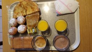 uma bandeja de alimentos para o pequeno-almoço e duas chávenas de sumo de laranja em Gîte O'Cigales em Sablet