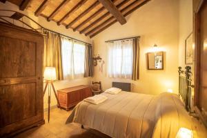 1 dormitorio con 1 cama, vestidor y ventanas en Il Fienile del Vichiaccio, en Mercatale Val Di Pesa