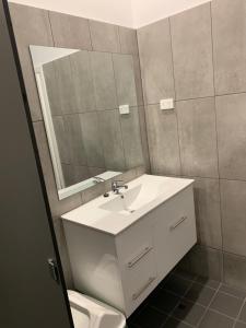 a bathroom with a sink, mirror, and bath tub at Garden Hotel in Dubbo