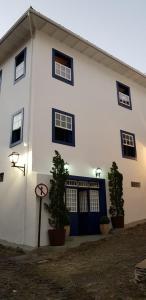 un edificio bianco con porte e finestre blu di Casa dos Meninos B&B a Ouro Preto
