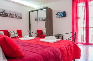 een slaapkamer met een rood bed en een spiegel bij Casa Euripide in Siracusa +56 foto's