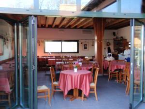 un restaurante con mesas y sillas con mantel rosa en Agriturismo Il Poggiolo, en Pianoro