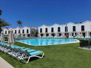 uma piscina com espreguiçadeiras e um resort em FBC Fortuny Resort - Adults Only em Maspalomas