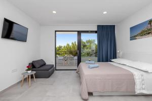 a bedroom with a bed and a couch and a balcony at Central Beach Apartments in Tučepi