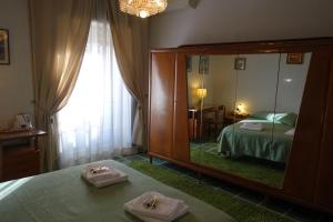 Habitación de hotel con espejo, cama y dormitorio en B&B Rome Downtown Deluxe, en Roma