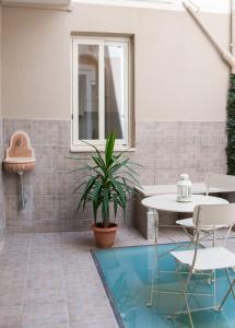 a patio with a table and chairs and a potted plant at Casa Euripide in Siracusa