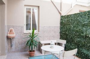 a patio with a table and chairs and a plant at Casa Euripide in Syracuse