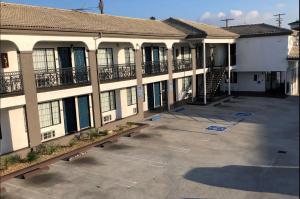 an empty parking lot in front of a building at Travelodge by Wyndham Harbor City in Harbor City