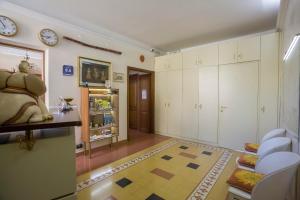 a living room with white cabinets and a clock on the wall at Anthony Guesthouse in Rome