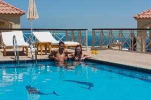 a man and a woman laying in a swimming pool at Lilly City Center Hostel in Hurghada