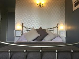 a bedroom with a bed with pillows on it at Riverside Cottage B&B in Lynmouth +45 photos