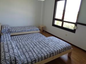 2 Betten in einem Zimmer mit Fenster in der Unterkunft Casa Deva in Candás