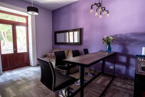 a dining room with purple walls and a table and chairs at Zocalo SENSACIONAL in Puebla
