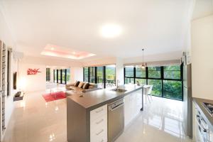 
a kitchen with a white counter top and white cabinets at Seclude Rainforest Retreat in Palm Grove
