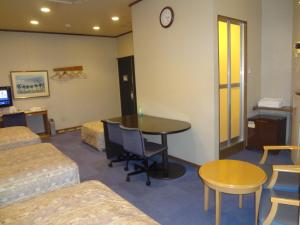 a hotel room with a table and a bed and a room at Asano Hotel in Kitakyushu