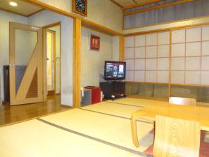 a room with a table and a tv in it at Asano Hotel in Kitakyushu